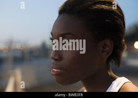 Giovane donna che guarda lontano Foto Stock