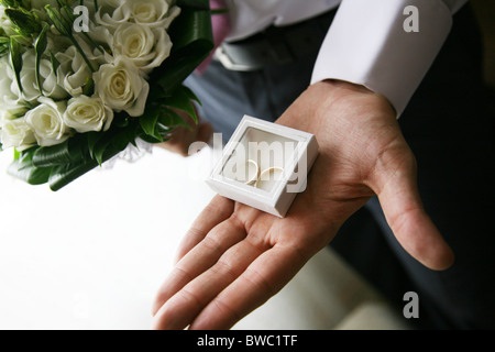 Close-up di piccoli confezione decorativa con due anelli di nozze in esso sulla palma umana Foto Stock