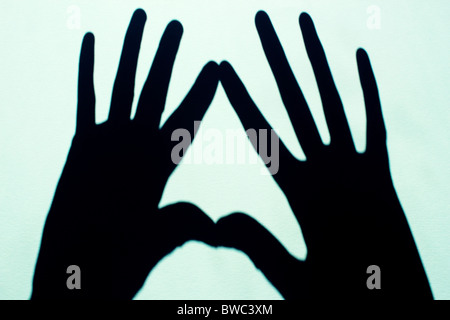 Due ombre a mano su fondo azzurro Foto Stock