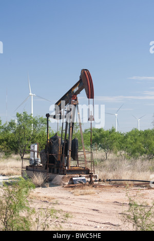 Pumpjack in un campo petrolifero adiacente ad una fattoria eolica di high-tech wind-turbine alimentate nella Panhandle regione del Texas Foto Stock