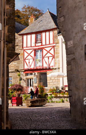 Giovane oltrepassando una casa medioevale in Rochefort en Terre Morbihan, in Bretagna, Francia Europa Foto Stock