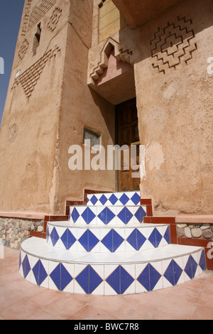 In piastrelle colorate gradini che conducono ad una porta di legno in una città del Marocco Foto Stock