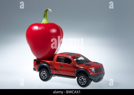 Un giocattolo carrello con frutta sul retro per mostrare il trasporto di fattoria in un astratto modo creativo Foto Stock