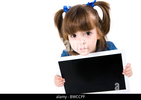 Ritratto di intelligent schoolgirl mostrando qualcosa sullo schermo del computer portatile e guardando la fotocamera Foto Stock