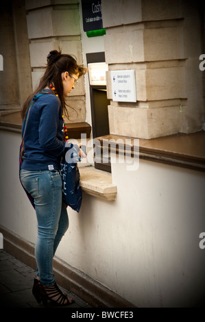 Una giovane donna con un Lloyds TSB bancomat macchina, REGNO UNITO Foto Stock