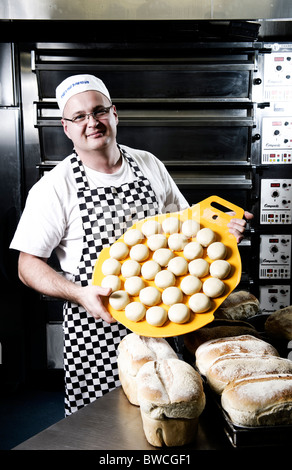 Panetteria tradizionale baker a lavorare con rotoli di pasta pronto per dimostrare, Devon, Regno Unito Foto Stock