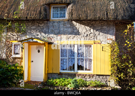 Un tipico piuttosto pietra inglese cottage con il tetto di paglia nel Wiltshire villaggio di Broad Chalke, England, Regno Unito Foto Stock