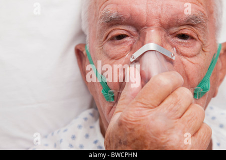 Stati Uniti d'America, Illinois, Metamora, Ritratto di uomo anziano con mascherina di ossigeno che giace nel letto di ospedale Foto Stock