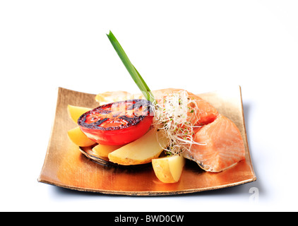 Filetto di salmone servito con patate e pomodoro grigliate Foto Stock