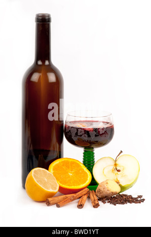 Vin brulé in un vetro circondato da ingredienti: arancio, limone, la cannella, i chiodi di garofano, zenzero, apple. Sul bianco. Foto Stock