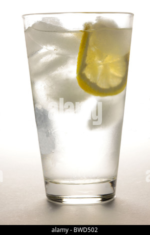 Bicchiere di acqua con ghiaccio e fetta di limone Foto Stock