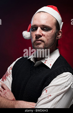 Orrore elf natale. Trucco e schizzi di sangue sul suo volto. Foto Stock