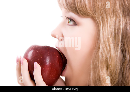 La ragazza con gli occhi verdi morde la grande mela rossa Foto Stock