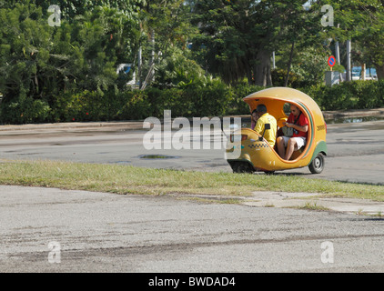 Giallo cubano coco taxi Buggy con i passeggeri su strada, l'Avana, Cuba, Ottobre 2010 Foto Stock