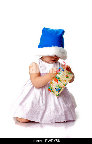 Bellissimo bambino in Santa del cappello con un presente isolato su bianco Foto Stock