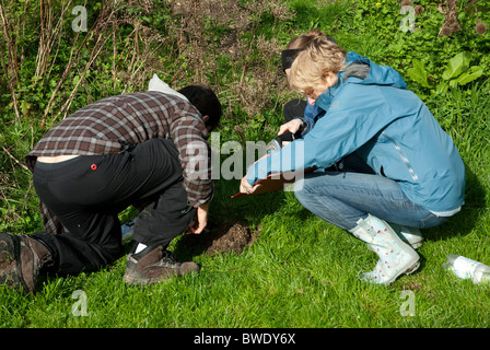 Prendere un campione di suolo su una progettazione con la Permacultura Foto Stock