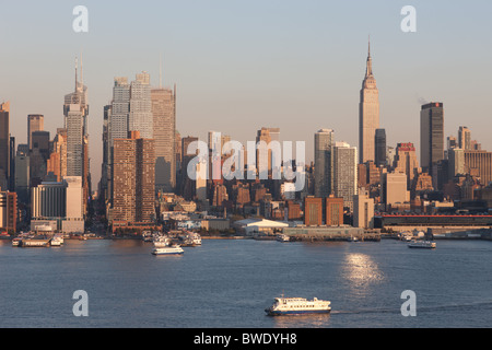 La skyline di Manhattan dietro a NY per via navigabile il traffico dei traghetti sul fiume Hudson in New York City. Foto Stock