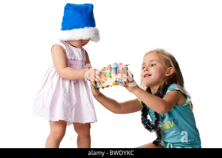 Bella ragazza dare un regalo a un bambino in Santa's hat isolato su bianco Foto Stock