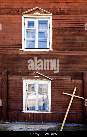Croce davanti alla casa in legno con due finestre, il lago Ladoga in Russia Foto Stock