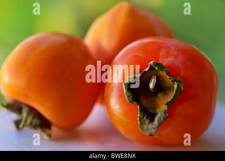 Caqui maturi frutti su sfondo verde. Foto Stock