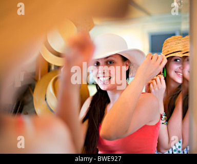 Giovani donne cercando su cappelli Foto Stock