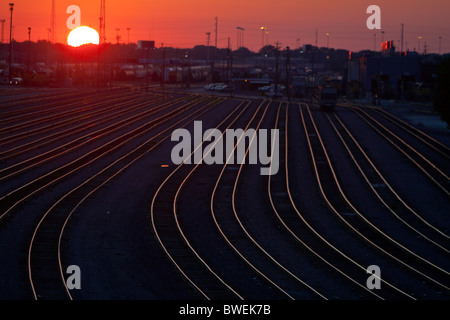 Il sole tramonta su un vuoto che la ferrovia freight yard in Chicago, IL. Foto Stock