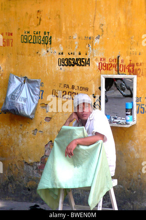 In Hanoi, una strada vietnamita barbiere in attesa per i clienti Foto Stock