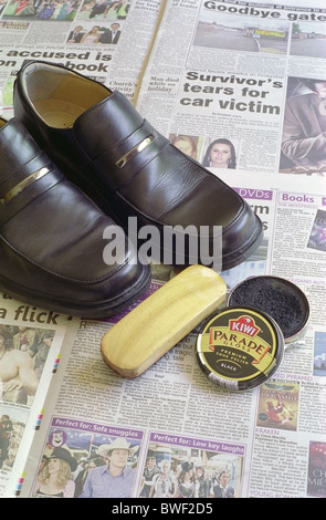 Coppia di marca Clarks Mens nero scarpe di cuoio sul giornale con Kiwi Brand Shoe Polish e spazzola Foto Stock