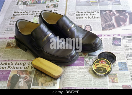 Coppia di marca Clarks Mens nero scarpe di cuoio sul giornale con Kiwi Brand Shoe Polish e spazzola Foto Stock