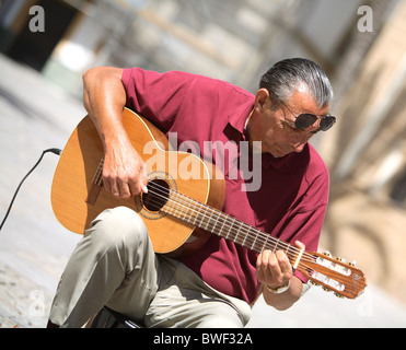 Busker riproduzione classica chitarra spagnola nella piazza della cattedrale di Cadice in Spagna. Foto Stock