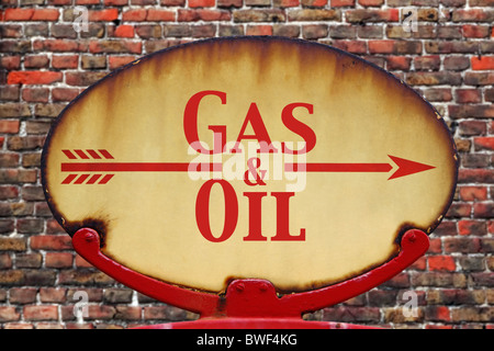 Un vecchio arrugginito retrò segno di freccia con il testo di olio e gas Foto Stock