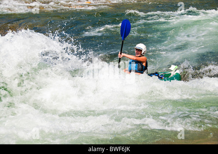 Stati Uniti d'America, Idaho, rafting, Medio Forcella del fiume di salmoni, donna matura kayak attraverso la zangolatura Mormorando di un ruscello. Foto Stock