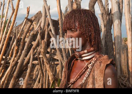 Giovani Hamar donna con argilla rossa tra i capelli e indossando un abito di capra, Omo river valley, sud Etiopia Foto Stock