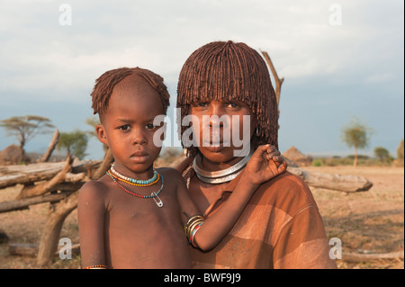 Giovani Hamar donna con argilla rossa nei capelli e il suo bambino, Omo river valley, sud Etiopia Foto Stock