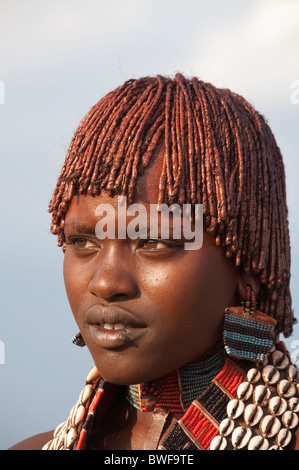 Ritratto di una giovane donna di Hamar con collane fatte di Cowry gusci e con argilla rossa nei suoi capelli, Omo river valley Etiopia Foto Stock