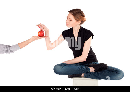 Slim donna sulla dieta tenendo red apple da una mano d'uomo isolato contro uno sfondo bianco Foto Stock