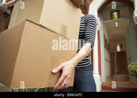 Donna che trasportano confezioni marroni da casa Foto Stock