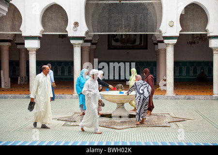 Islamic adoratori di purificare se stessi in corrispondenza di una abluzione fontana a una moschea nella Medina, la città vecchia di Fes, Marocco. Foto Stock