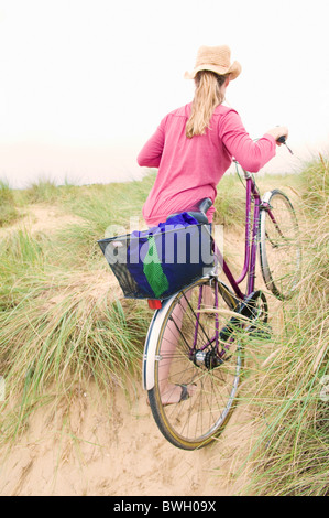 Donne spinge in bicicletta sulla spiaggia Foto Stock