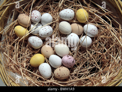 Piccola pasqua di cioccolato mini uova sulla paglia in un cesto di paglia. Foto Stock