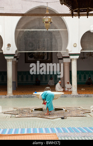 Islamic adoratori di purificare se stessi in corrispondenza di una abluzione fontana a una moschea nella Medina, la città vecchia di Fes, Marocco. Foto Stock