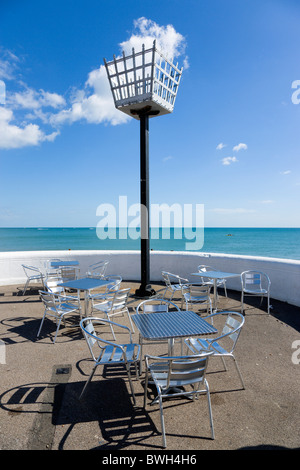 Inghilterra West Sussex Bognor Regis millennio faro sul lungomare accanto alla spiaggia con vuoti di metallo tavoli e sedie sotto Foto Stock