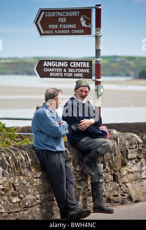 Locali irlandesi gli uomini in chat dal quayside in Courtmacsharry, County Cork, Irlanda Foto Stock