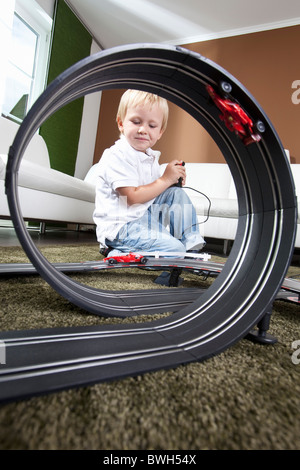 Ragazzo giocando con slot car racing via Foto Stock