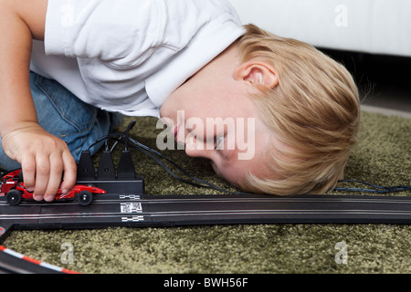 Ragazzo giocando con la fessura della pista Foto Stock