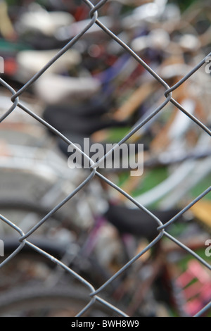 Al di fuori della messa a fuoco delle biciclette dietro il pollo filo mesh Foto Stock