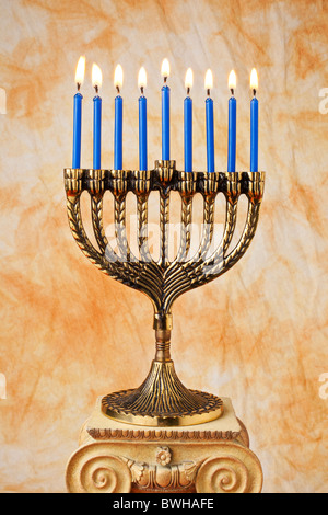 Il Menorah con candele blu sul piedistallo Foto Stock