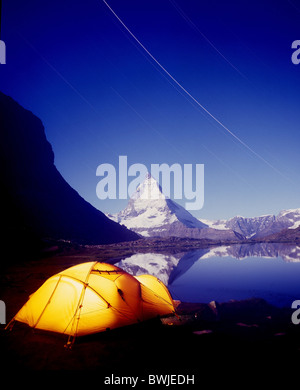 Cervino tenda da campeggio tende campeggio luce accesa lago di montagna lago Riffelsee crepuscolo crepuscolo di notte n Foto Stock