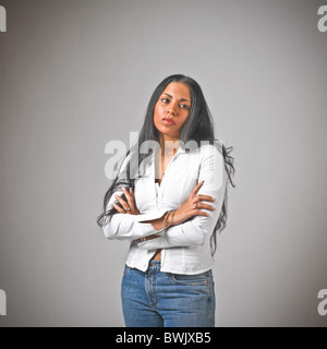 I giovani ispanici femmina donna abiti casual, jeans, il linguaggio del corpo, con le braccia incrociate Foto Stock