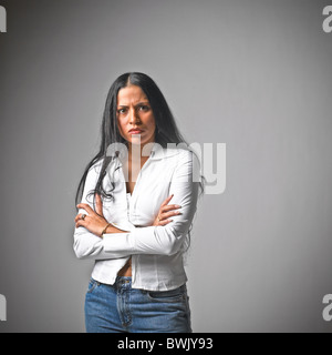I giovani ispanici femmina donna abiti casual, jeans, il linguaggio del corpo, con le braccia incrociate Foto Stock